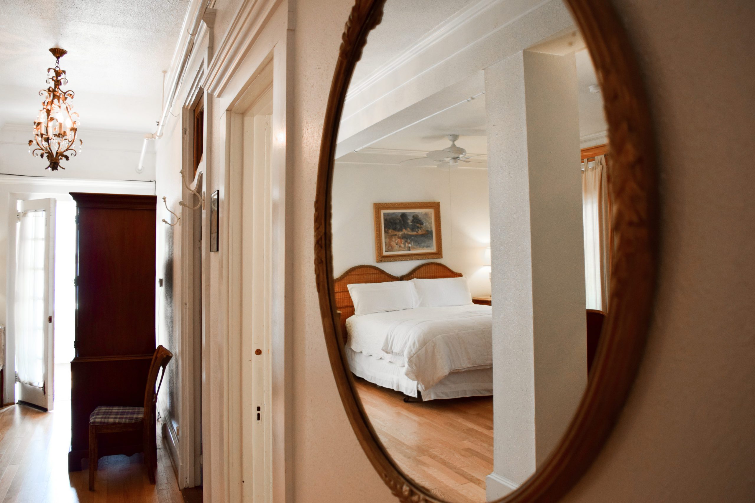 Bedroom reflected in wall mirror.